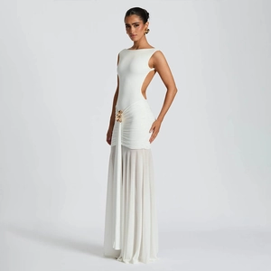 Detailed side view of white backless maxi dress with waist pleats and golden ornament