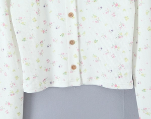Gros plan sur le tissu en maille côtelée à fleurs avec boutons et motifs floraux