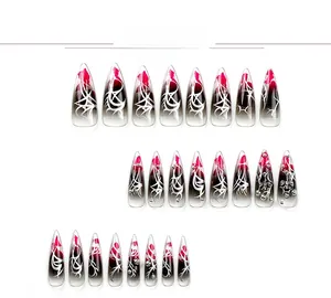 Detail of stiletto press-on nails with red-black gradient and gothic silver patterns