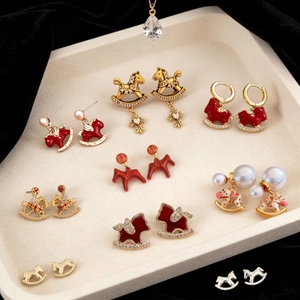 Detailed collection of 18k gold plated horse earrings with enamel and pearls on a tray