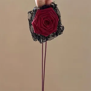 Macro shot of dark red satin rose with black lace detail and ties for choker or hair