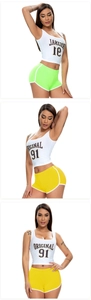 Vertical view of women's sports set with white crop top and bright elastic yoga shorts