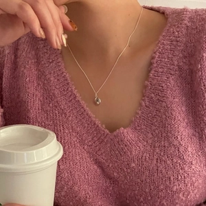 Delicate 925 sterling silver teardrop necklace on model with purple knit sweater background