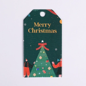 Detail of green Christmas gift tag with festive tree illustration and Merry Christmas text