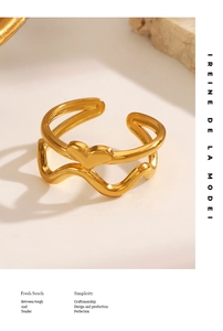 Macro detail of gold layered heart open ring with a polished wavy band design
