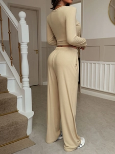Back view of a beige knitted two-piece set featuring long-sleeve top and wide-leg trousers
