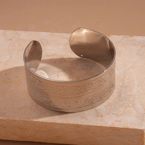 Detail of bohemian engraved butterfly patterns on wide silver open bangle bracelet