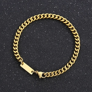 Détail d'un bracelet gourmette doré en acier inoxydable avec étiquette rectangulaire et fermoir