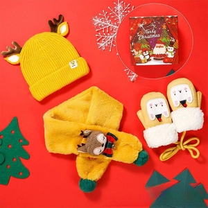 Close-up of baby Christmas gift set with elk hat, scarf, and gloves in a red holiday box
