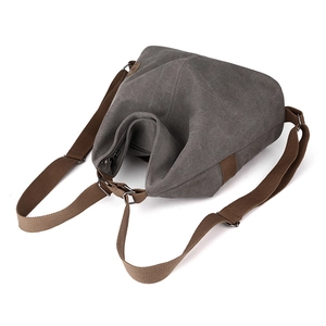Versatile grey canvas backpack for women with brown straps and metal zipper closure