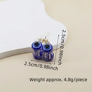 Detailed view of evil eye hair claw clip with blue eye pattern and silver metal spring