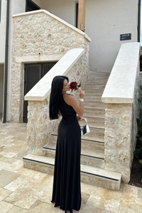 Detail of elegant black maxi dress with waist pleats and flowing silhouette