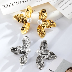 Textured gold and silver flower petal earrings with center pearl in a stylish group view