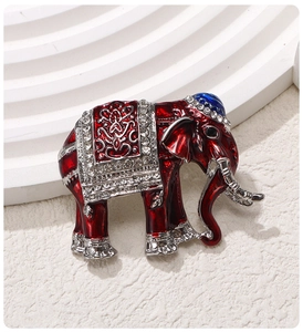 Detailed macro shot of a red enamel elephant brooch with silver edging and crystals