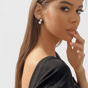 Gothic vintage spider stud earrings with white faux pearls on female model