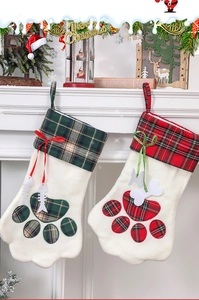 Détail de chaussettes de Noël en peluche pour animaux avec revers à carreaux et breloques