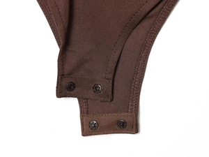Macro shot of brown nylon bodysuit bottom with dual snap button closures and knit texture