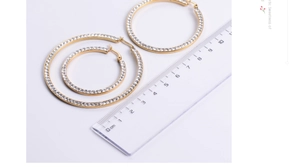 Three sizes of gold titanium steel hoop earrings with crystals measured by a ruler