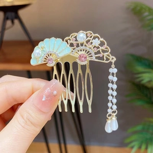 Detail of golden hair comb with blue enamel fans, pink rhinestones and pearl tassels