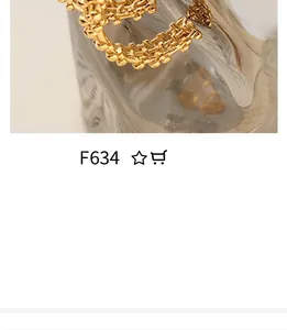 Close-up of gold-plated woven metal ring featuring a layered heart-shaped design