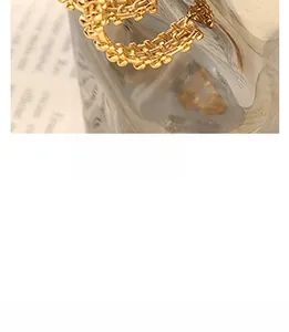 Close-up of gold-plated woven metal ring featuring a layered heart-shaped design