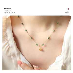 Detail of 18K gold-plated shell pendant necklace featuring translucent emerald green beads