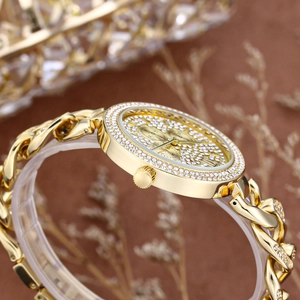 Detail of a luxury gold-plated ladies watch with sparkling rhinestones and cuban chain
