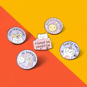 Detailed view of colorful enamel cat and dog pins with positive quote engravings