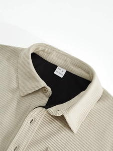 Macro detail of beige corduroy collar with Size M and 100% polyester label on inner lining