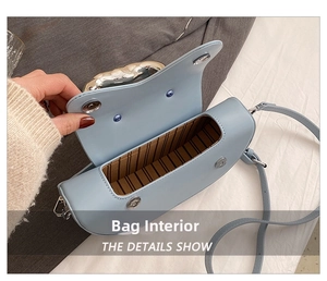 Gros plan d'un sac à main bleu clair avec fermoir magnétique et doublure en tissu rayé