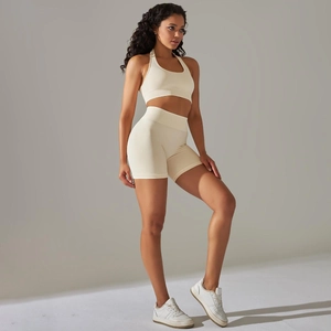 Detail of seamless ribbed knit yoga set featuring high waist shorts and halter sports bra