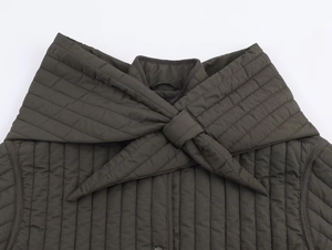 Détail de la veste matelassée vert olive foncé avec grand col à nœud papillon