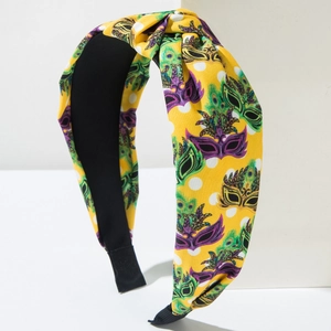 Close-up of fabric knotted headband with carnival mask prints and white polka dots