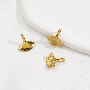 Detailed view of three 14K gold-plated ginkgo leaf pendants with fine leaf vein texture