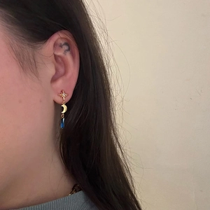 Detail of S925 silver star and moon drop earring with blue pendant on model