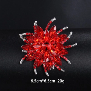Detail view of red crystal flower brooch with silver diamond accents on black leather