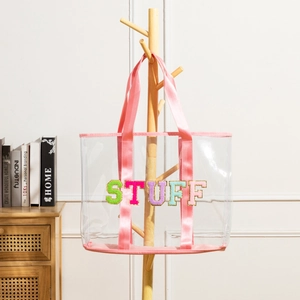 Large clear PVC tote bag with pink straps and colorful fuzzy STUFF chenille letter patches