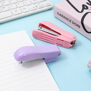Mini macaron portable staplers in pink and purple colors on a tidy office desk