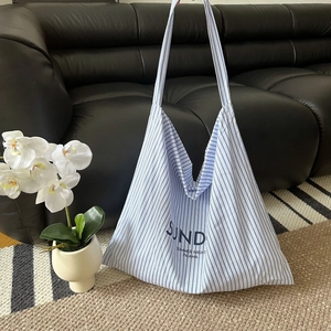 Detail of blue and white striped canvas tote bag with Sunday Summer Night Pajama text