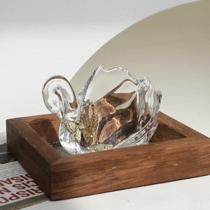 Vintage swan-shaped clear glass storage jar for jewelry display on a wooden base