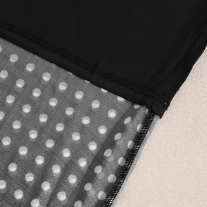 Detail of black polka dot mesh splicing and precision stitching on the two-piece set