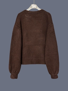 Detailed back view of a thick brown knit cardigan showing high-quality textured weaving