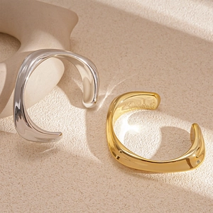 Modern irregular wave metal bangle in gold and silver finish with high-gloss polish
