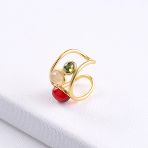 Multi-layer gold crystal ring featuring red green and white stones on textured fabric