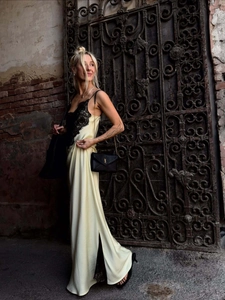 Detailed view of champagne satin dress with black lace trim and high side slit