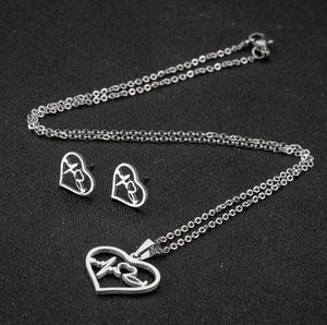 Gros plan sur l'ensemble collier et boucles d'oreilles ECG en argent sur fond noir