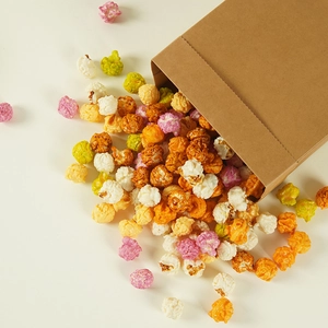 Modelo de palomitas esféricas de colores realistas vertidas de una bolsa de papel