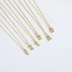 Close-up of golden bear pendants with sparkling zircons on elegant fine chain necklaces