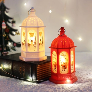 LED Christmas lanterns with Santa and Snowman designs on vintage books background