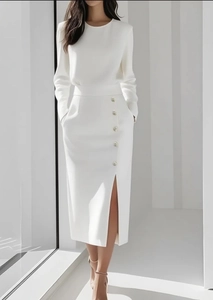 Detail view of white pencil skirt featuring decorative buttons and a side slit design